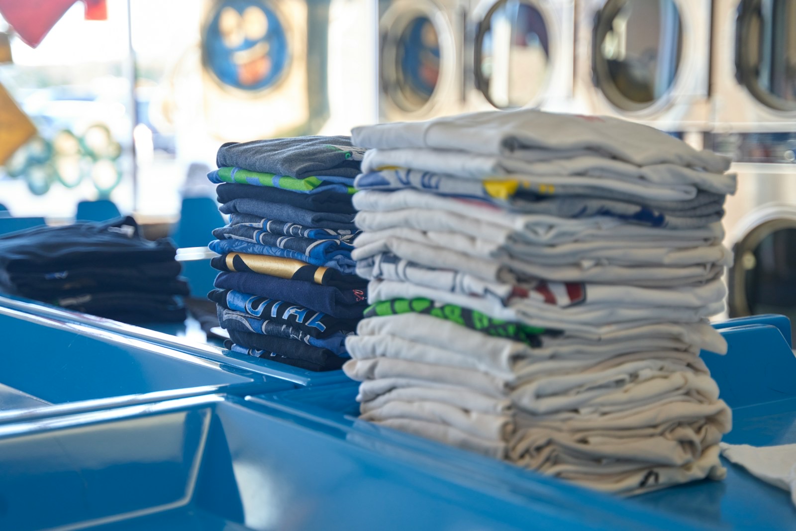 Stacks of freshly folded T-shirts on a counter